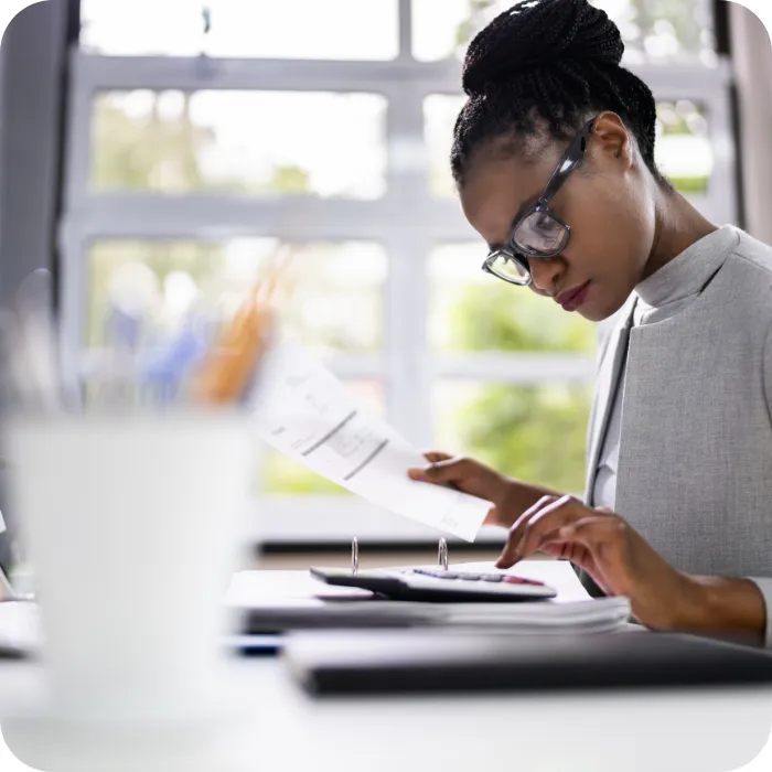 Woman in an office working on paperwork, focused and serious.