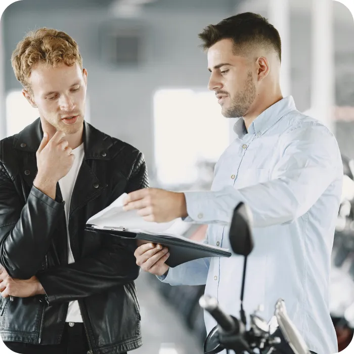 Two men discussing over a document in a bright room.