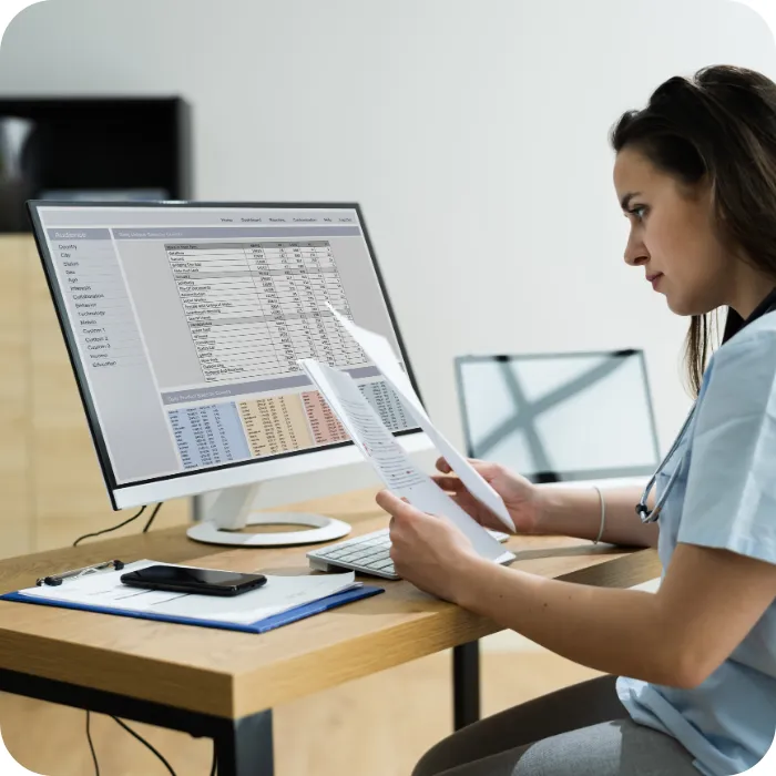 Doctor analyzing medical records on a desktop.