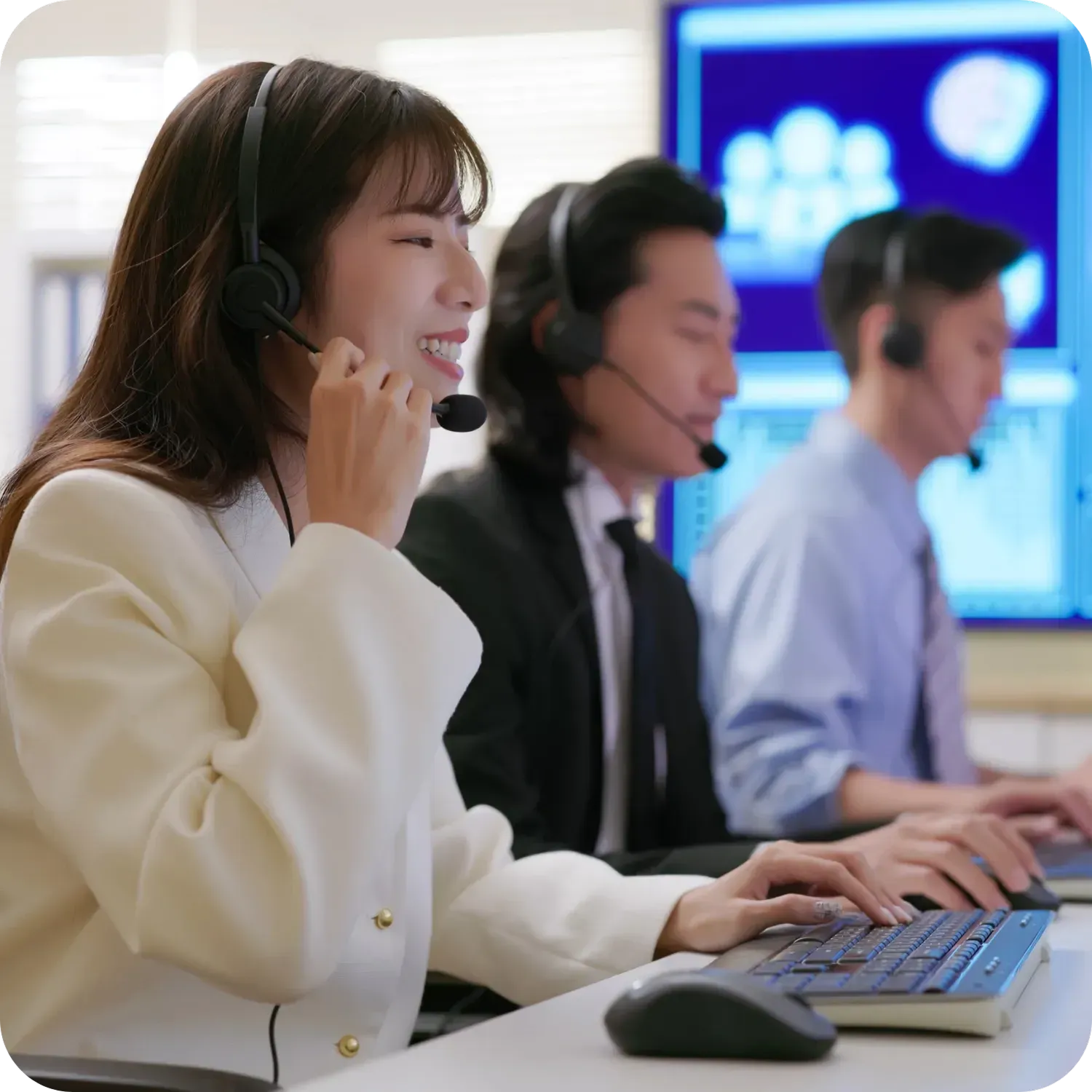 Call center employees working with headsets and computers.