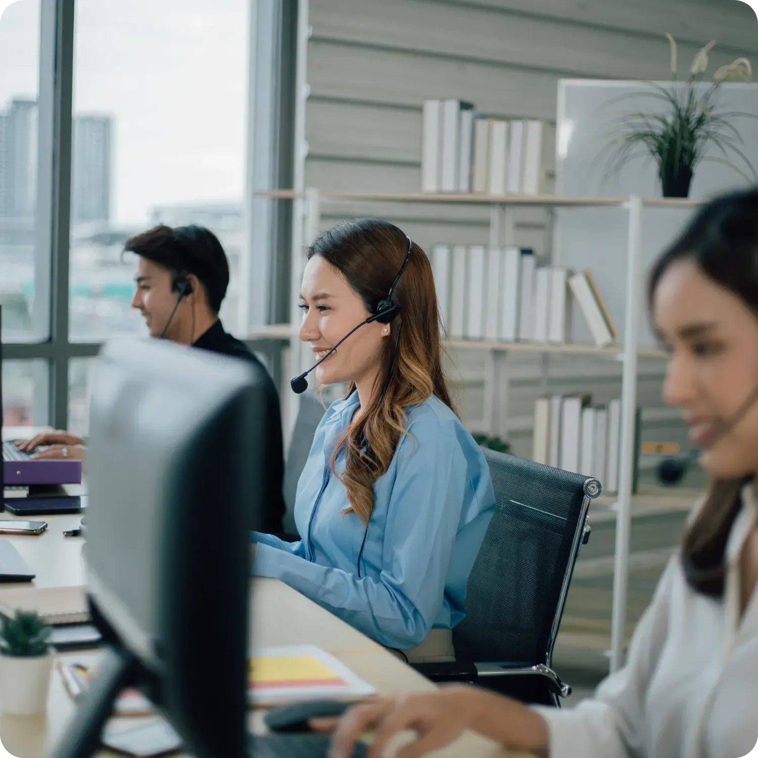 Call center employees working at desks wearing headsets.