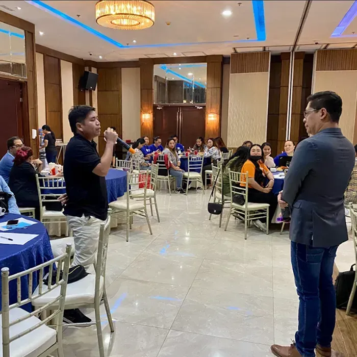 Elegant banquet hall with people interacting around tables.