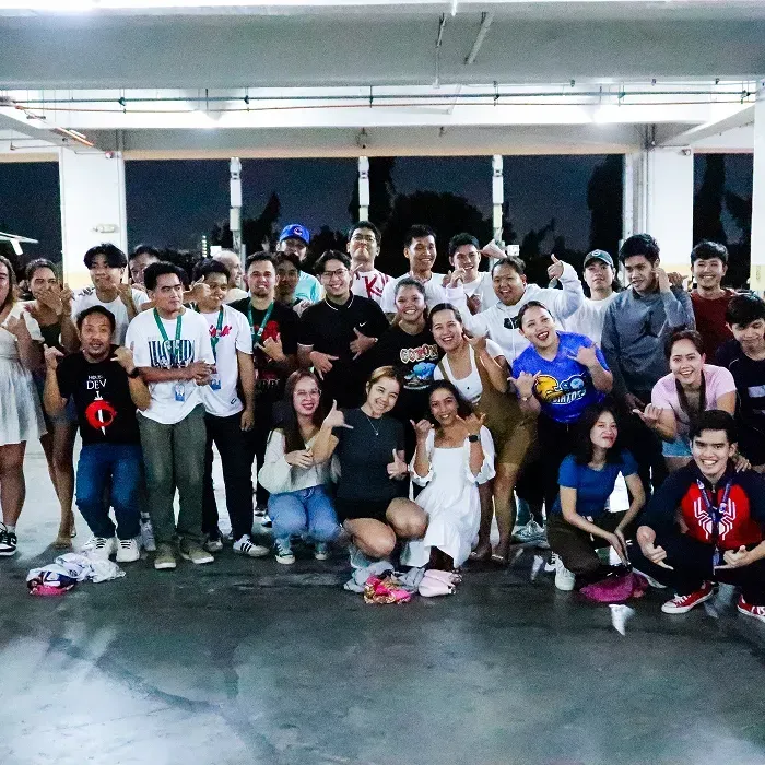 A large group of people smiling in a brightly lit room.